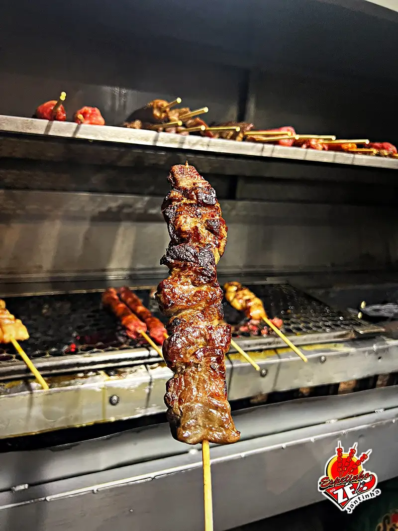 Espetinho de carne suculento saindo da brasa