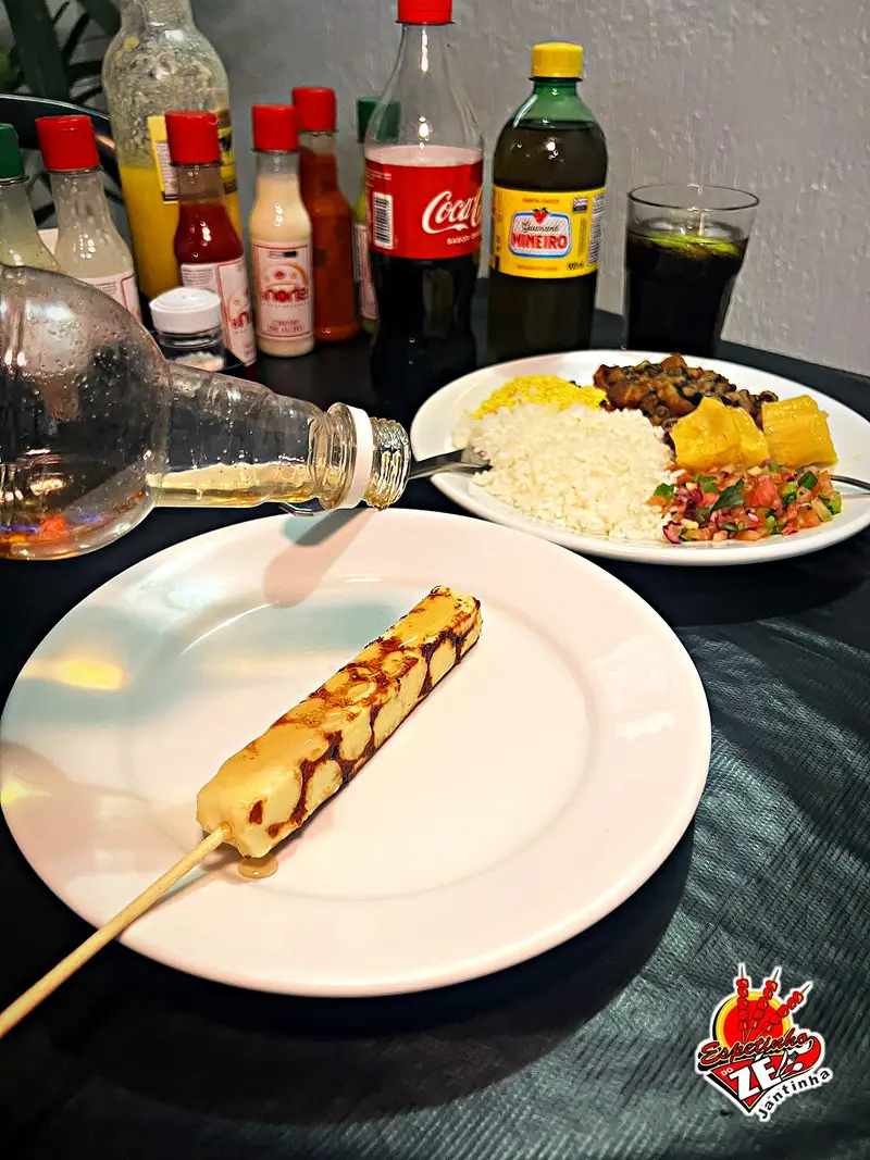 Espetinho de queijo coalho dourado na brasa sendo servido
